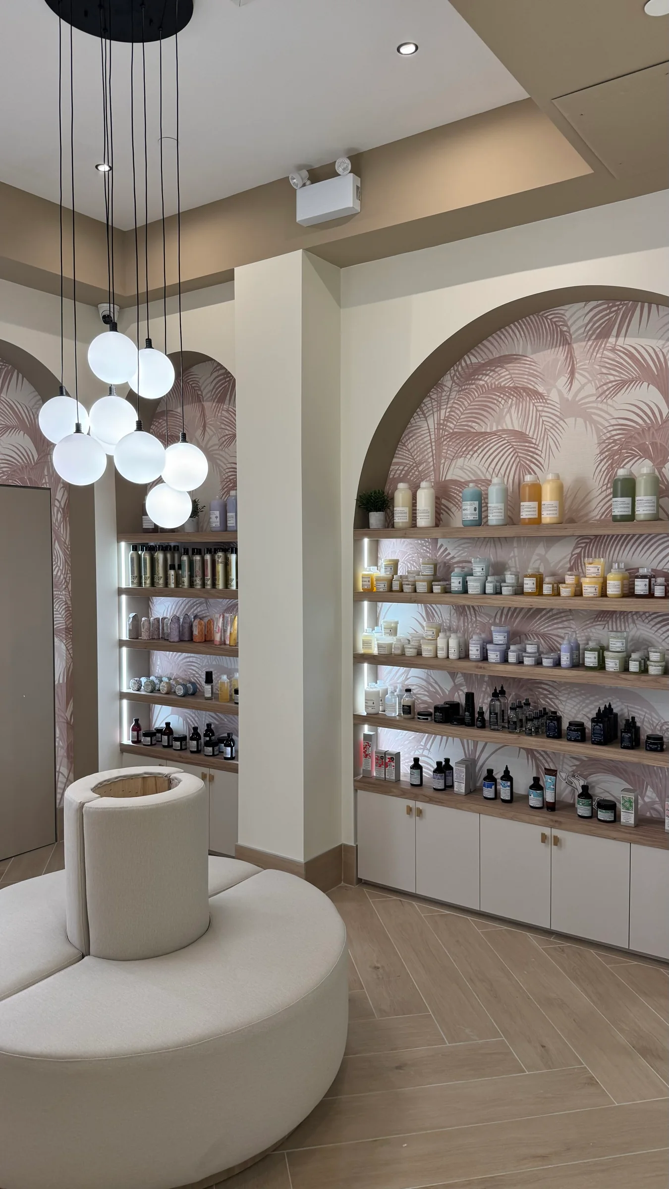 Haircare display shelves and curved seating in Salon Capelli's reception area