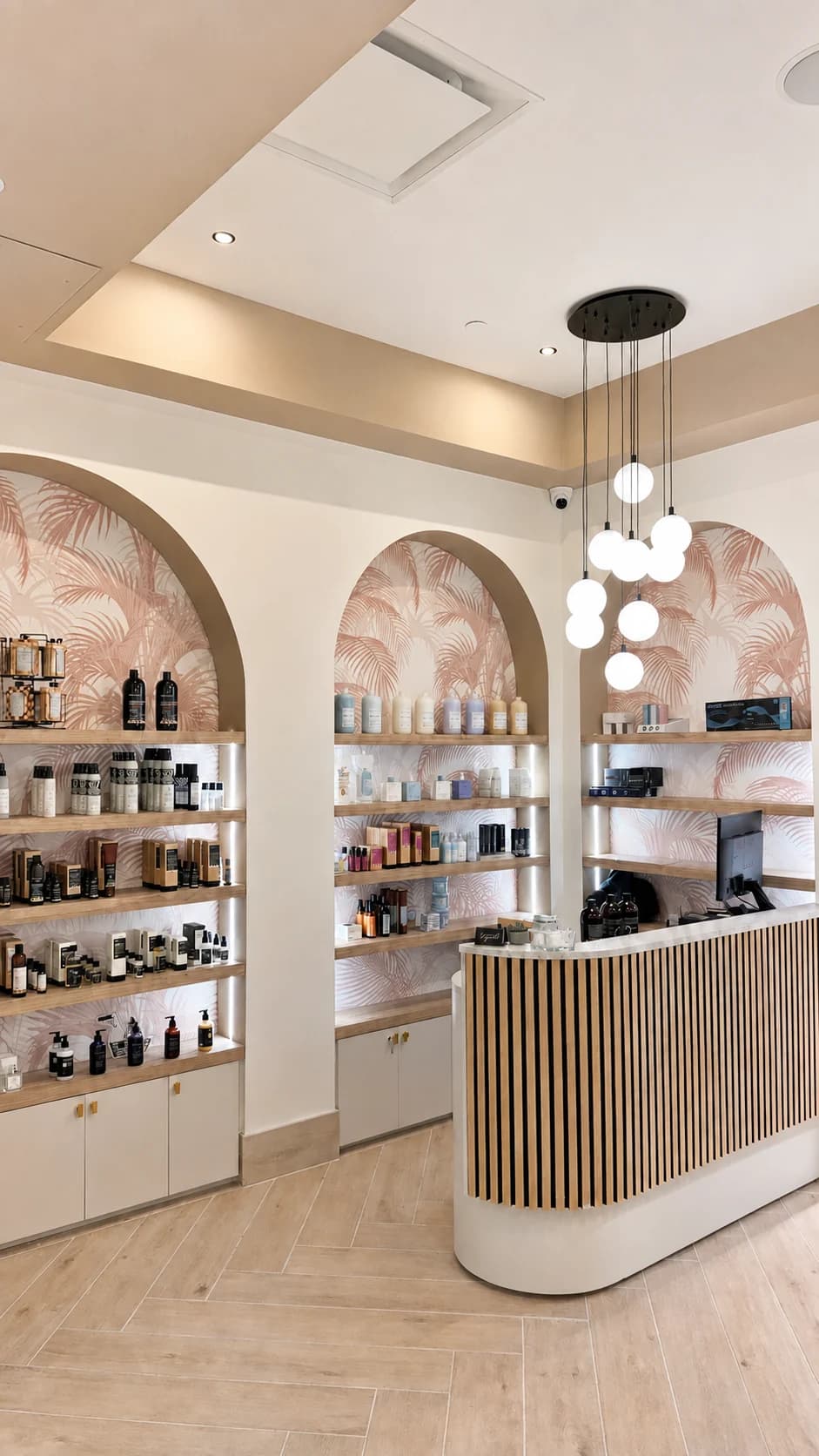 Salon Capelli reception desk framed by arched product shelves and pendant lights