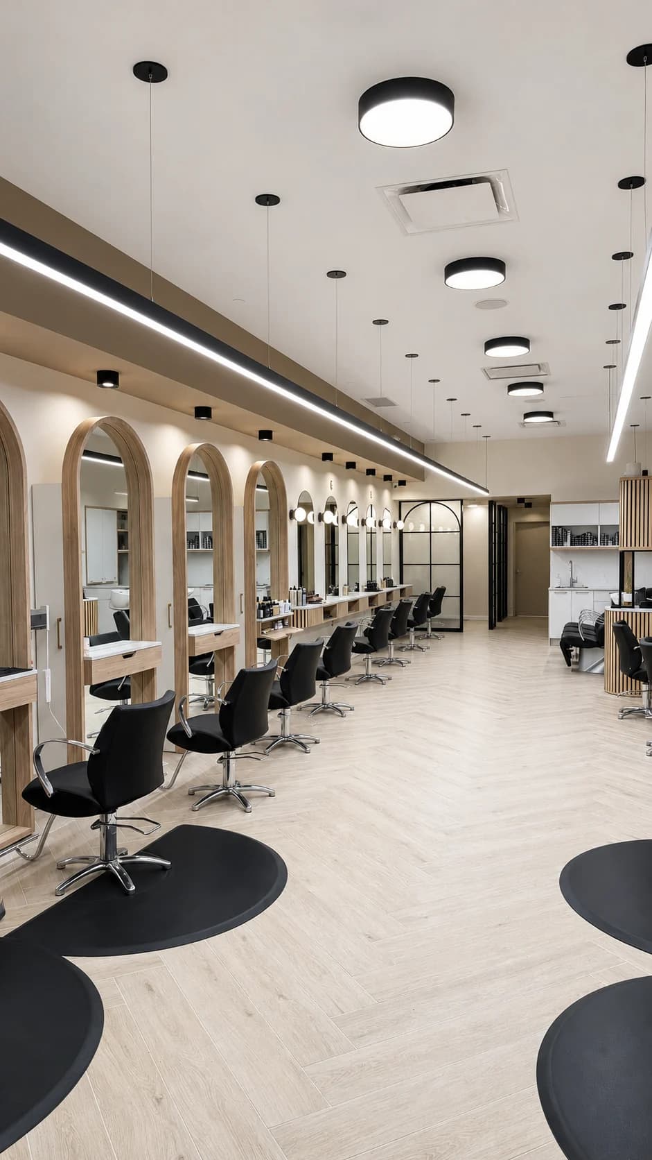 Salon styling floor with black chairs, arched mirrors, and pale wood flooring