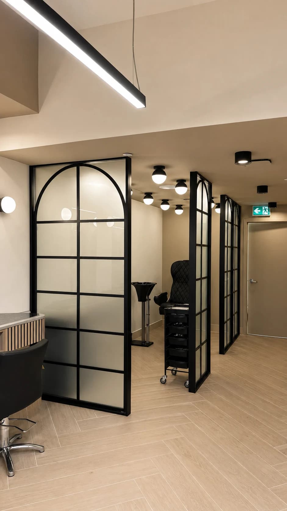 Black arched glass partition and hallway at the back of Salon Capelli
